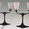 Art Deco table lamps on wrought iron bases.