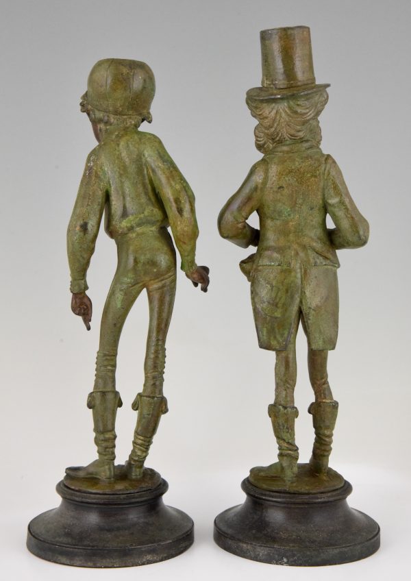 A pair of figural candlesticks jockey and gentleman