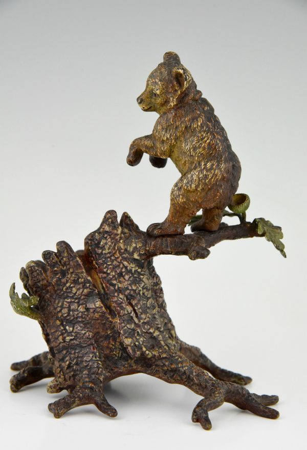 Antique Vienna bronze bear on a tree trunk