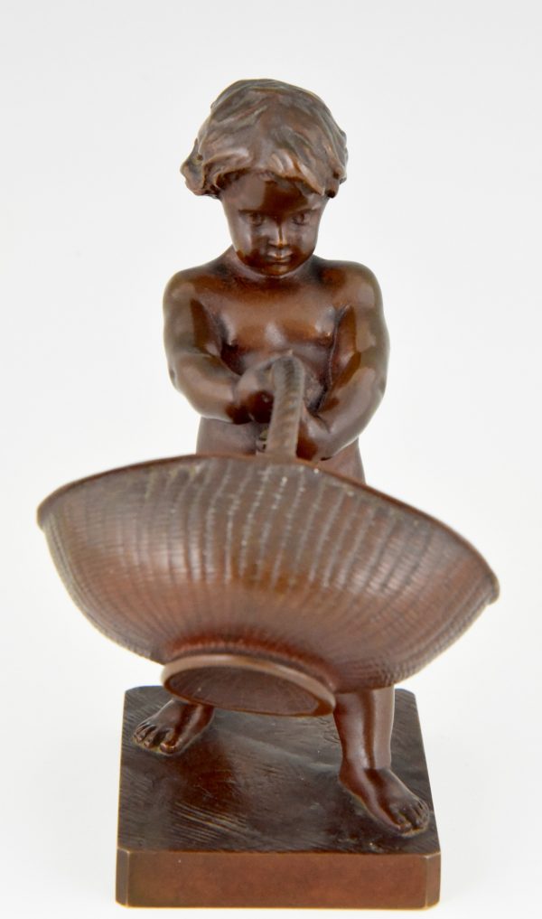 Antique bronze of a boy with basket