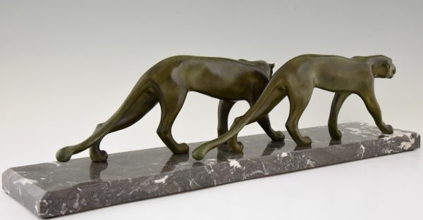 Art Deco sculpture of two walking panthers.