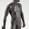 Antique bronze sculpture of a standing male nude fencer.