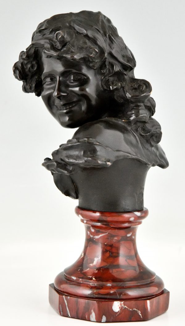 Antique bronze bust of a smiling child.