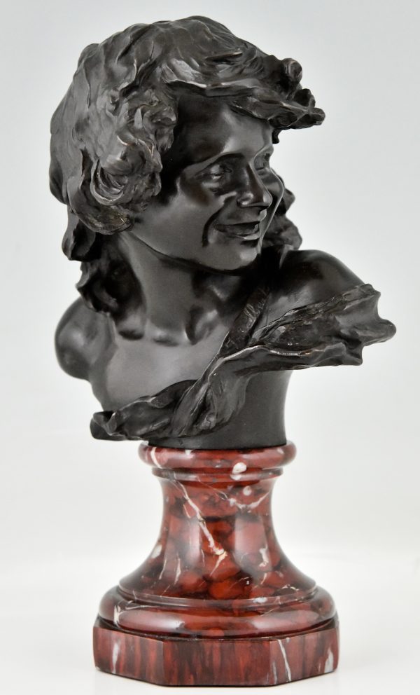 Antique bronze bust of a smiling child.