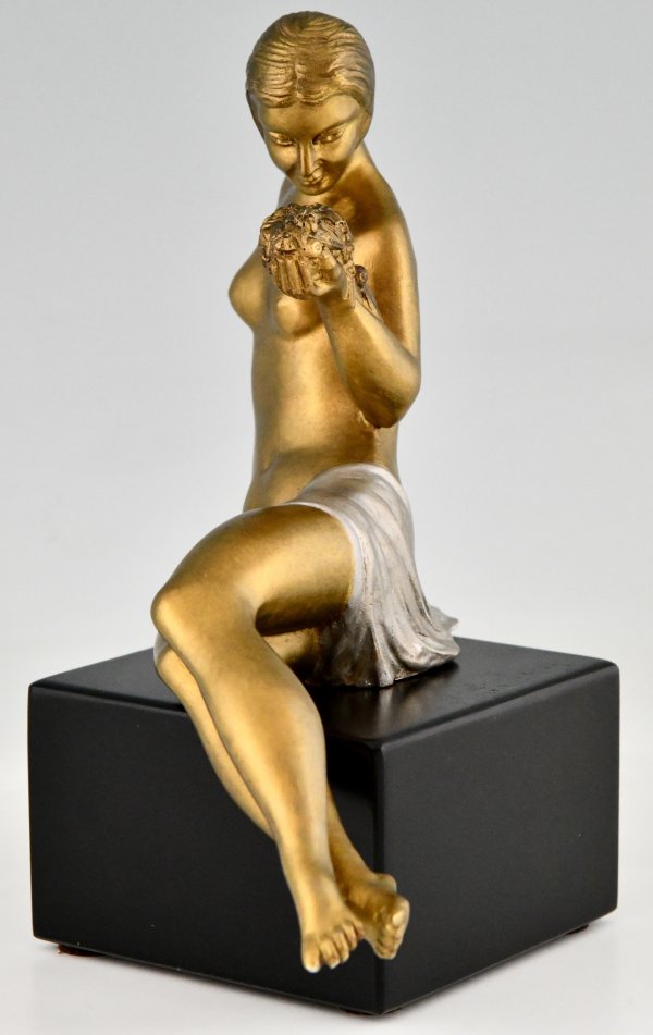 Art Deco bronze sculpture seated nude with flowers.