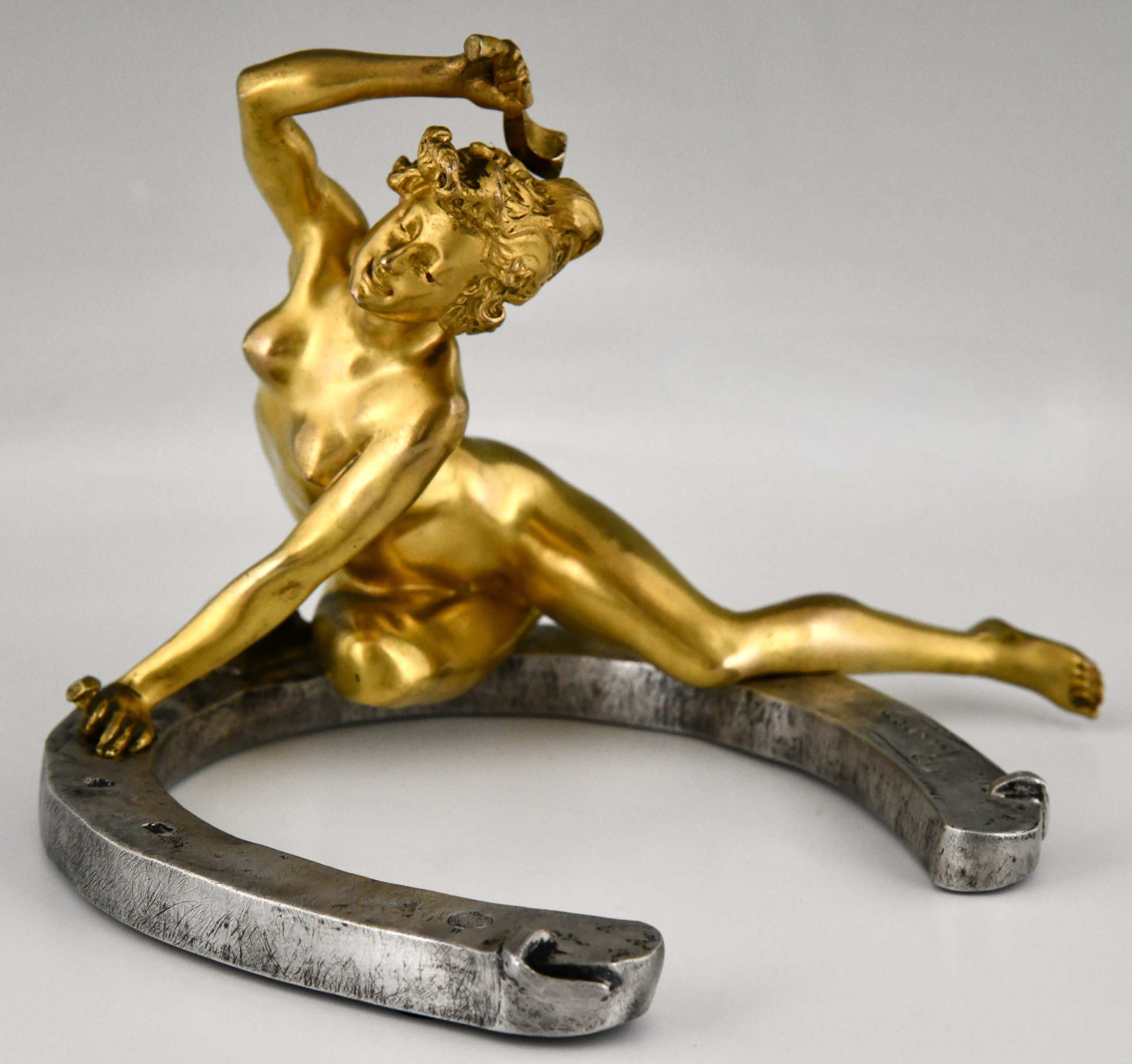 Art Nouveau bronze sculpture nude on horseshoe.  