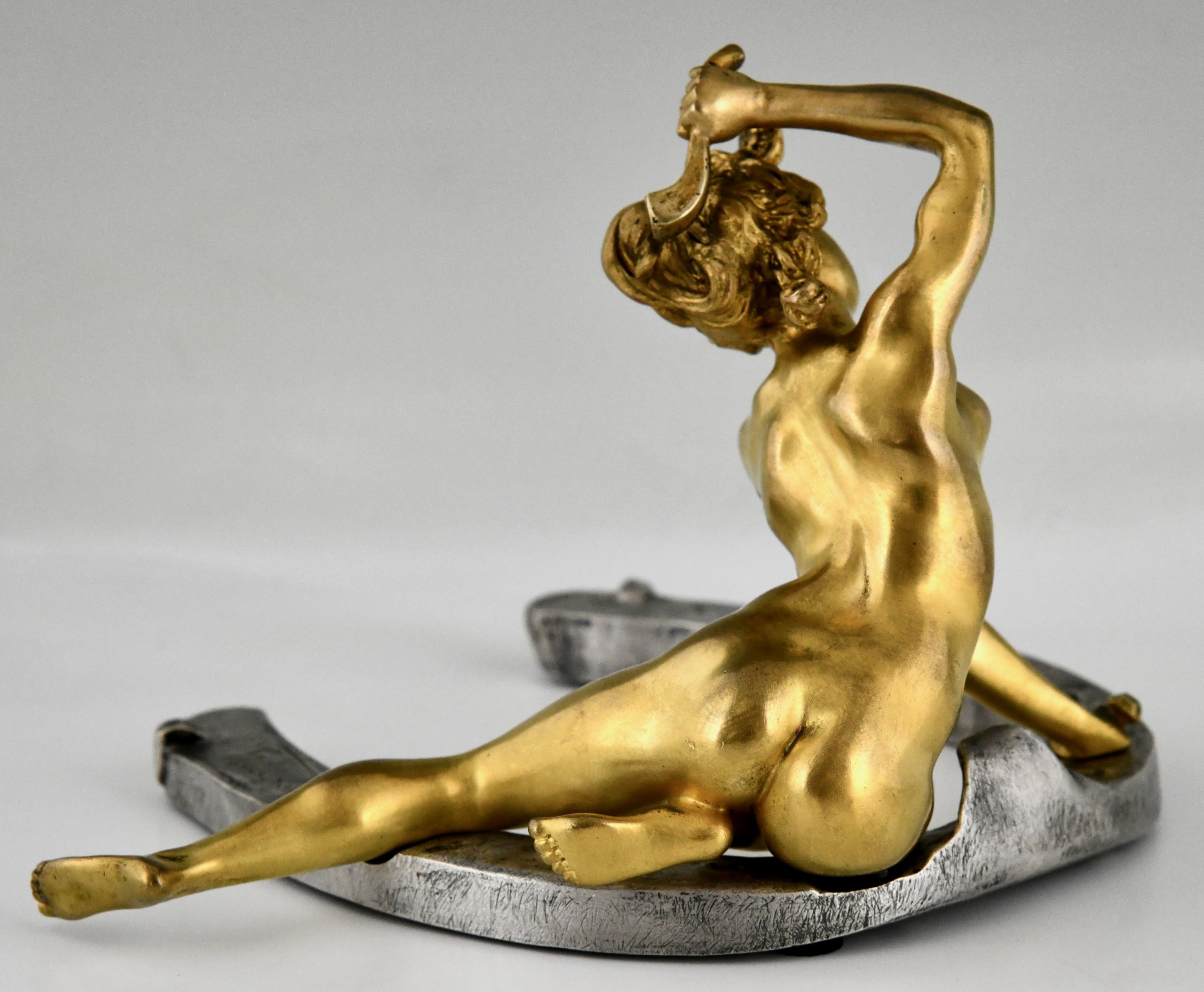 Art Nouveau bronze sculpture nude on horseshoe.  